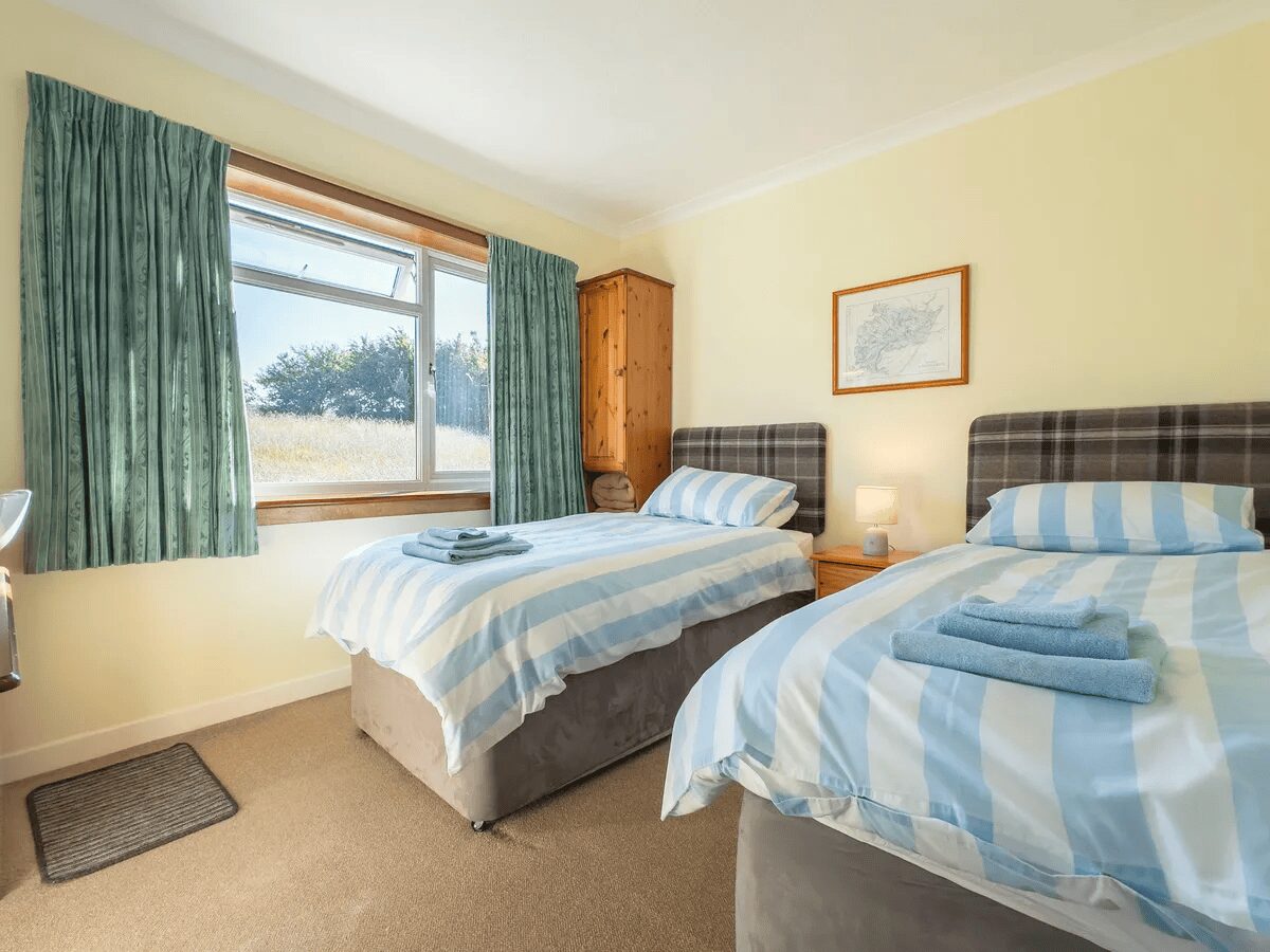 Twin bedroom at Otter Lodge Skye with scenic window view