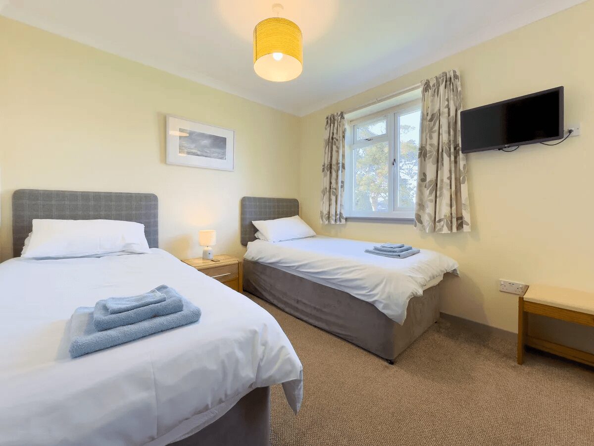 Twin bedroom suite at Otter Lodge with TV and modern furnishings